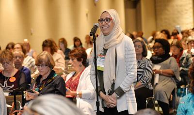 Woman in hijab speaking in a microphone during a conference event